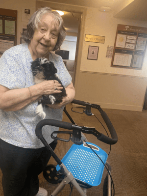 woman holding therapy dog and smiling